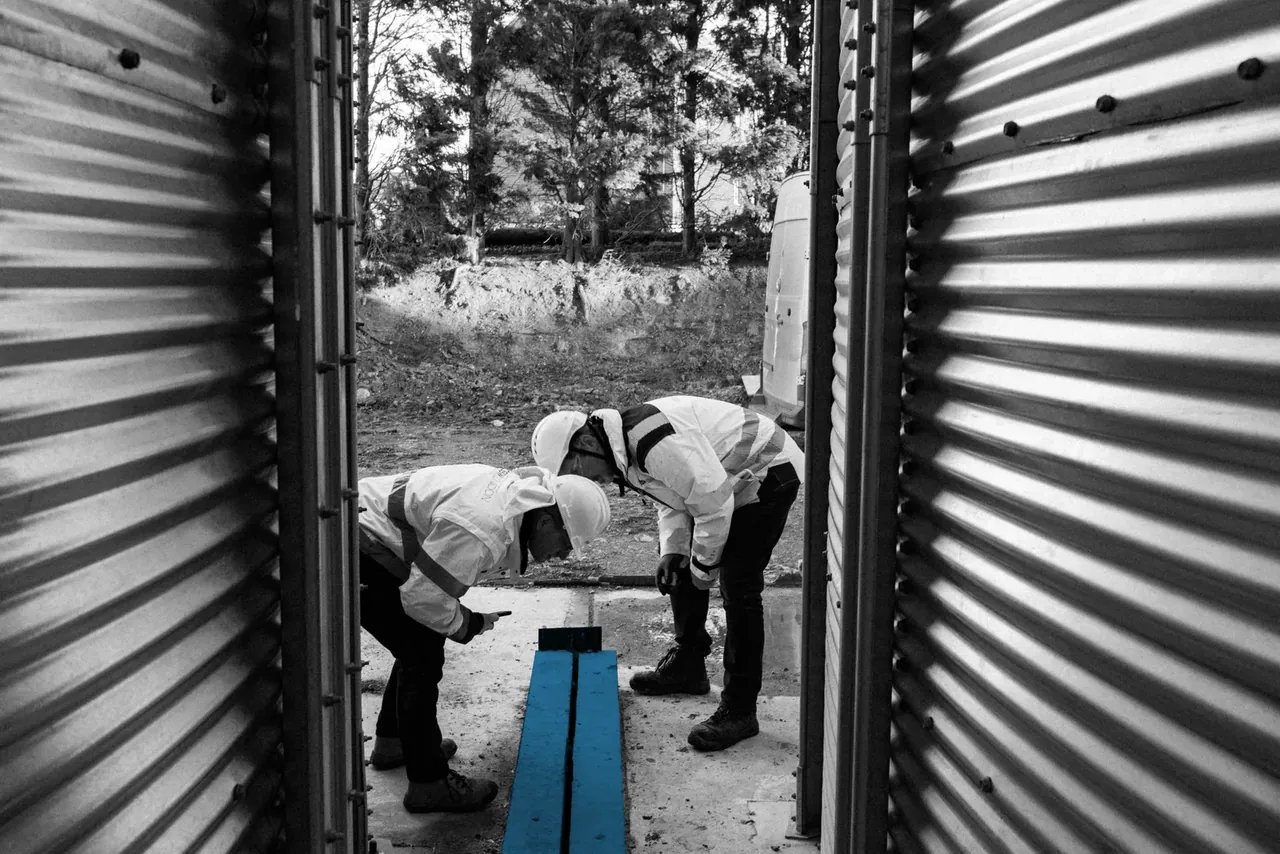 Two CLW consultants in PPE inspecting a below-ground drainage detail on site