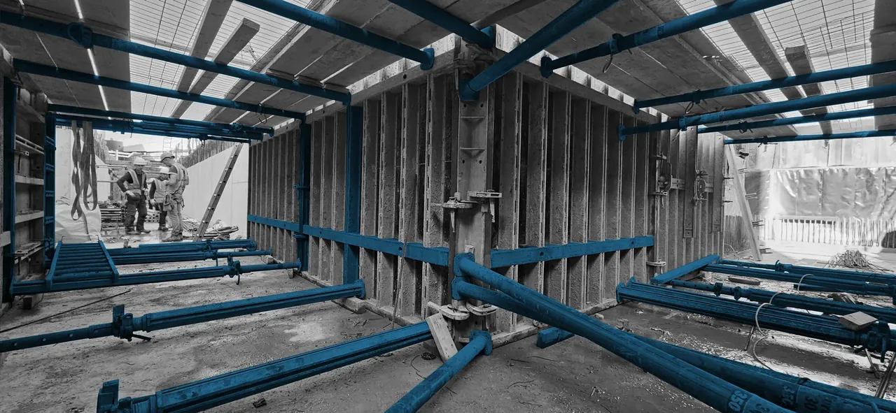 Double-sided wall formwork and propping inside a reinforced concrete basement box under construction